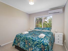 A bedroom with a bed and nightstand at Cozy Cottage - Whitianga Holiday Home Whitianga