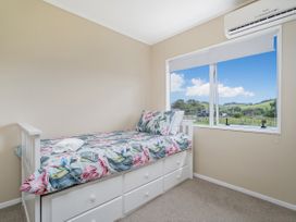 A bedroom with a bed and window at Cozy Cottage - Whitianga Holiday Home Whitianga