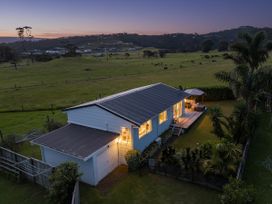 A house with a deck and garden at Cozy Cottage - Whitianga Holiday Home Whitianga