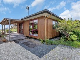 A wooden house with a pergola and steps at Matapouri Holiday Home Whangarei