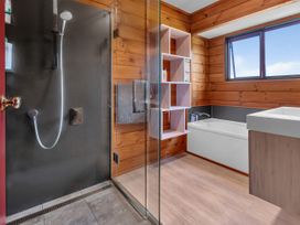A bathroom with a shower, bathtub, and sink at Matapouri Holiday Home in Whangarei