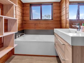 A bathroom with a bathtub and sink at Matapouri Holiday Home in Whangarei
