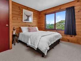 A bedroom with a bed and side table at Matapouri Holiday Home in Whangarei