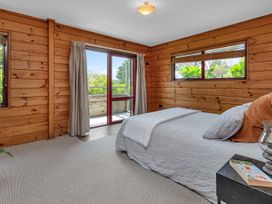 A bedroom with a bed and sliding door at Matapouri Holiday Home Whangarei