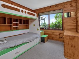 A bedroom with a bed and shelves at Matapouri Holiday Home in Whangarei