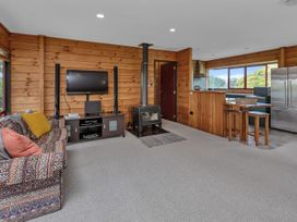 A living room with a sofa and television at Matapouri Holiday Home in Whangarei