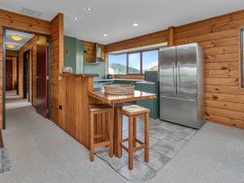 A kitchen with a bar counter and stools at Matapouri Holiday Home in Whangarei