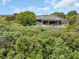 A house with a patio and outdoor furniture at Matapouri Holiday Home Whangarei