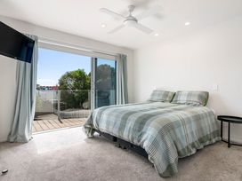 A bedroom with a bed and TV at Happy Place - Waihi Beach Holiday Home Waihi Beach