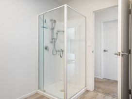 A shower with glass door in a bathroom at Happy Place - Waihi Beach Holiday Home