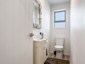 A bathroom with a sink and toilet at Happy Place - Waihi Beach Holiday Home, Waihi Beach