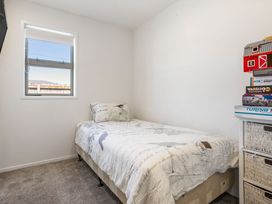 A bedroom with a bed and shelf at Happy Place - Waihi Beach Holiday Home in Waihi Beach