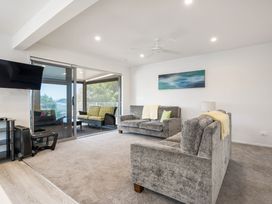 A living room with sofas and a television at Happy Place - Waihi Beach Holiday Home, Waihi Beach