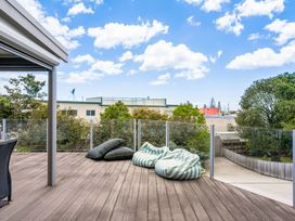 An outdoor deck with bean bags and a glass railing at Happy Place - Waihi Beach Holiday Home, Waihi Beach