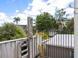 An outdoor shower area with fence and foliage at Happy Place - Waihi Beach Holiday Home Waihi Beach