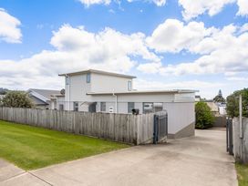 A house with a fence and driveway at Happy Place - Waihi Beach Holiday Home Waihi Beach