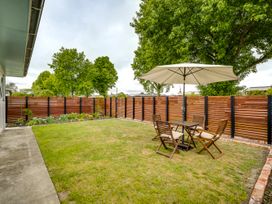 A garden with a table and chairs under an umbrella at Cozy on Clive - Hastings