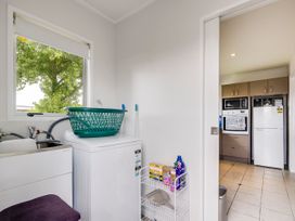 A laundry room with a washing machine and laundry basket at Cozy on Clive - Hastings