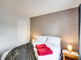 A bedroom with a bed and towels at Cozy on Clive - Hastings