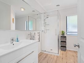 A bathroom with a shower and sink at Papamoa Beach in Papamoa
