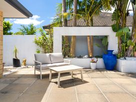 An outdoor patio with a sofa and coffee table at Papamoa Beach in Papamoa