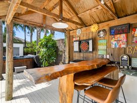 An outdoor bar with a wooden counter and stools at Papamoa Beach in Papamoa