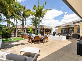 An outdoor patio with furniture and a hot tub at Papamoa Beach in Papamoa