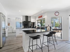 A kitchen with an island and bar stools at Papamoa Beach in Papamoa