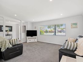 A living room with a television and sofa at Papamoa Beach in Papamoa