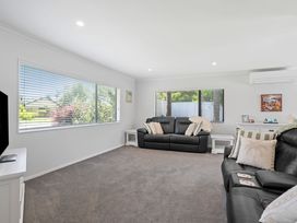 A living room with sofas and a television at Papamoa Beach in Papamoa