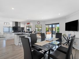 A kitchen with a dining area and modern appliances at Papamoa Beach, Papamoa