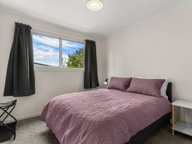 A bedroom with a bed and curtains at Amanda Lane - Snells Beach Holiday Home Snells Beach