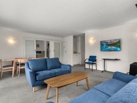 A living room with a sofa and television at Amanda Lane - Snells Beach Holiday Home, Snells Beach