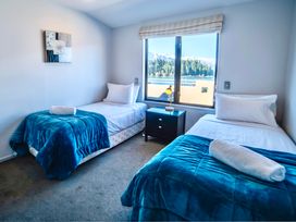 A bedroom with two single beds and a nightstand at Lakefront Penthouse - Central Queenstown Holiday Home Queenstown