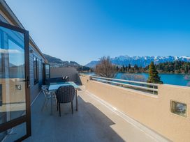 An outdoor seating area with a table and chairs at Lakefront Penthouse - Central Queenstown Holiday Home Queenstown