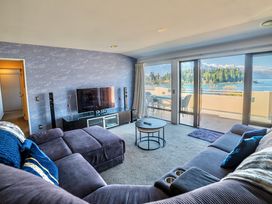 A living room with a television and a sofa at Lakefront Penthouse - Central Queenstown Holiday Home Queenstown