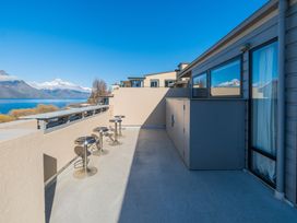 A balcony with bar stools and a view of mountains and lake at Lakefront Penthouse - Central Queenstown Holiday Home in Queenstown