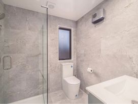 A bathroom with a shower, toilet, and sink at Hanmer Alpine - Hanmer Holiday Home Hanmer Springs