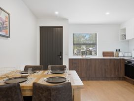 A dining room with a table and kitchen area at Hanmer Alpine Chalet - Hanmer Holiday Home