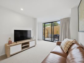 A living room with a television and sofa at Hanmer Alpine Chalet - Hanmer Holiday Home Hanmer Springs