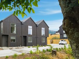 Two houses with a driveway and a car at Hanmer Alpine Chalet - Hanmer Holiday Home Hanmer Springs