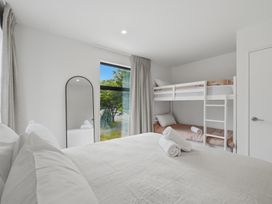 A bedroom with a large bed and a bunk bed at Hanmer Alpine Chalet - Hanmer Holiday Home