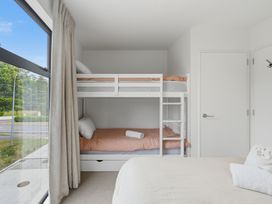 A bedroom with a bunk bed and a single bed at Hanmer Alpine Chalet - Hanmer Holiday Home