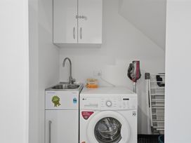 A laundry room with a washing machine and sink at Hanmer Alpine Chalet - Hanmer Holiday Home