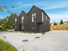 A building with multiple windows and a parking lot at Hanmer Alpine Chalet - Hanmer Holiday Home Hanmer Springs