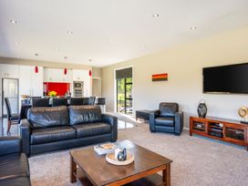 A living room with a sofa and television at Lake Hawea Holiday Home in Wanaka
