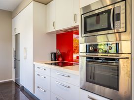 A kitchen with appliances including refrigerator, microwave, and oven at Lake Hawea Holiday Home in Wanaka