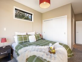 A bedroom with a bed and bedside lamp at Lake Hawea Holiday Home in Wanaka
