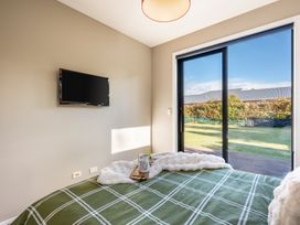A bedroom with a bed and television at Lake Hawea Holiday Home in Wanaka