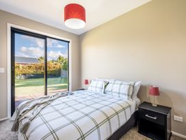 A bedroom with a bed and nightstand at Lake Hawea Holiday Home in Wanaka